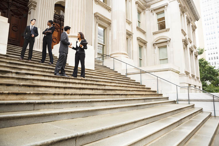 Four well dressed professionals in discussion on the exterior steps of a building. Could be lawyers, government workers, business people etc., Four well dressed professionals in discussion on the exterior st Four well dressed professionals in discussion on the exterior steps of a building. Could be lawyers, government workers, business people etc.